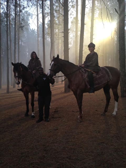 Horses and riders in a misty forest during a commercial shoot